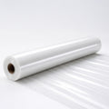 A roll of clear plastic sheeting lies on a white surface.
