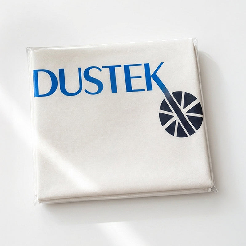 Folded Dustek filter bag packaged neatly in clear plastic, showcasing logo branding. Clean, simple presentation highlights product readiness, storage convenience, and professional appearance for industrial and replacement filter bag use.