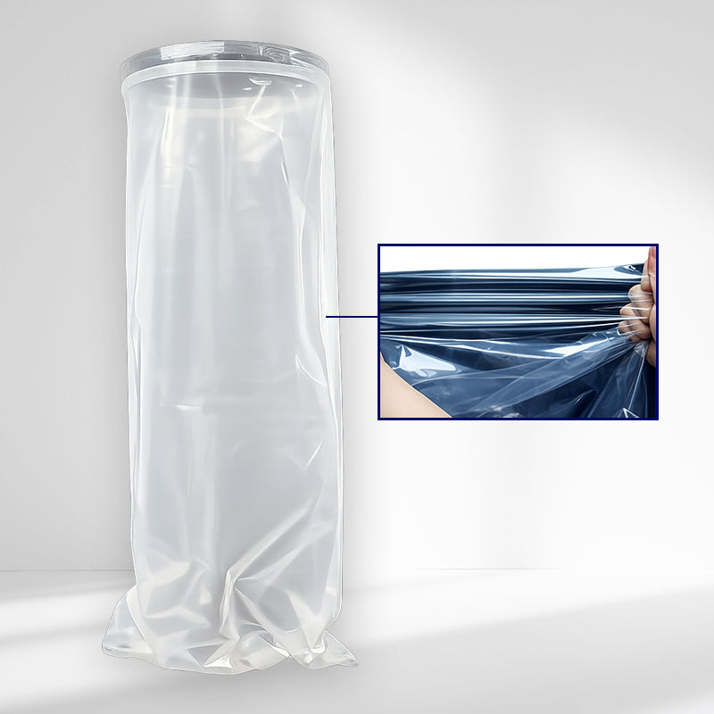 The image shows a tall, cylindrical roll or sleeve of transparent plastic standing upright against a clean, light gray background. The material is gathered loosely at the bottom, creating soft folds and a slightly crumpled, glossy appearance that catches the light. It looks thin, flexible, and highly reflective, with subtle highlights running vertically along the surface.